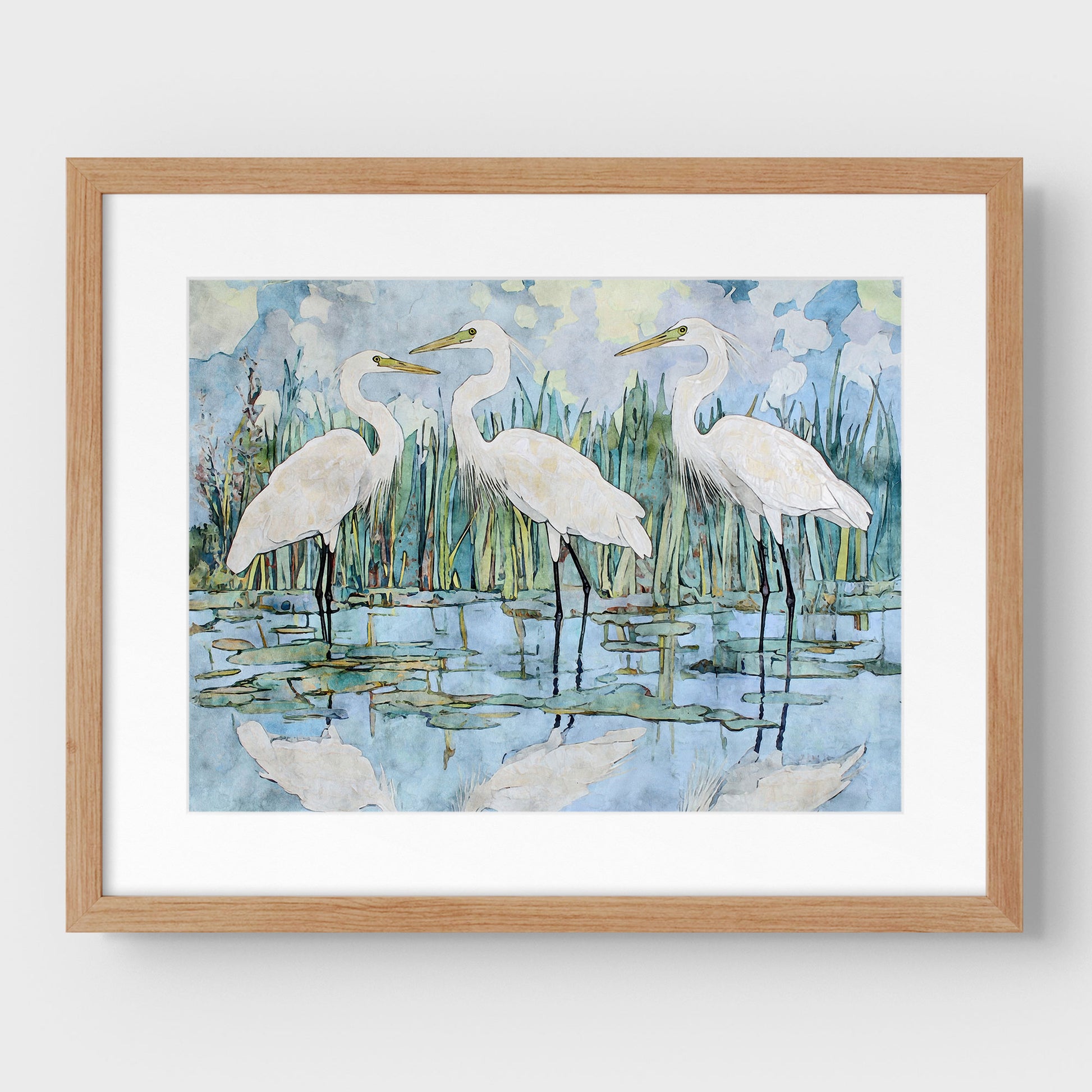 Framed artwork of three white birds in a natural setting with a wooden frame.