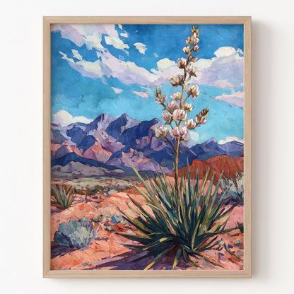 Framed artwork of a desert landscape with mountains and a plant.