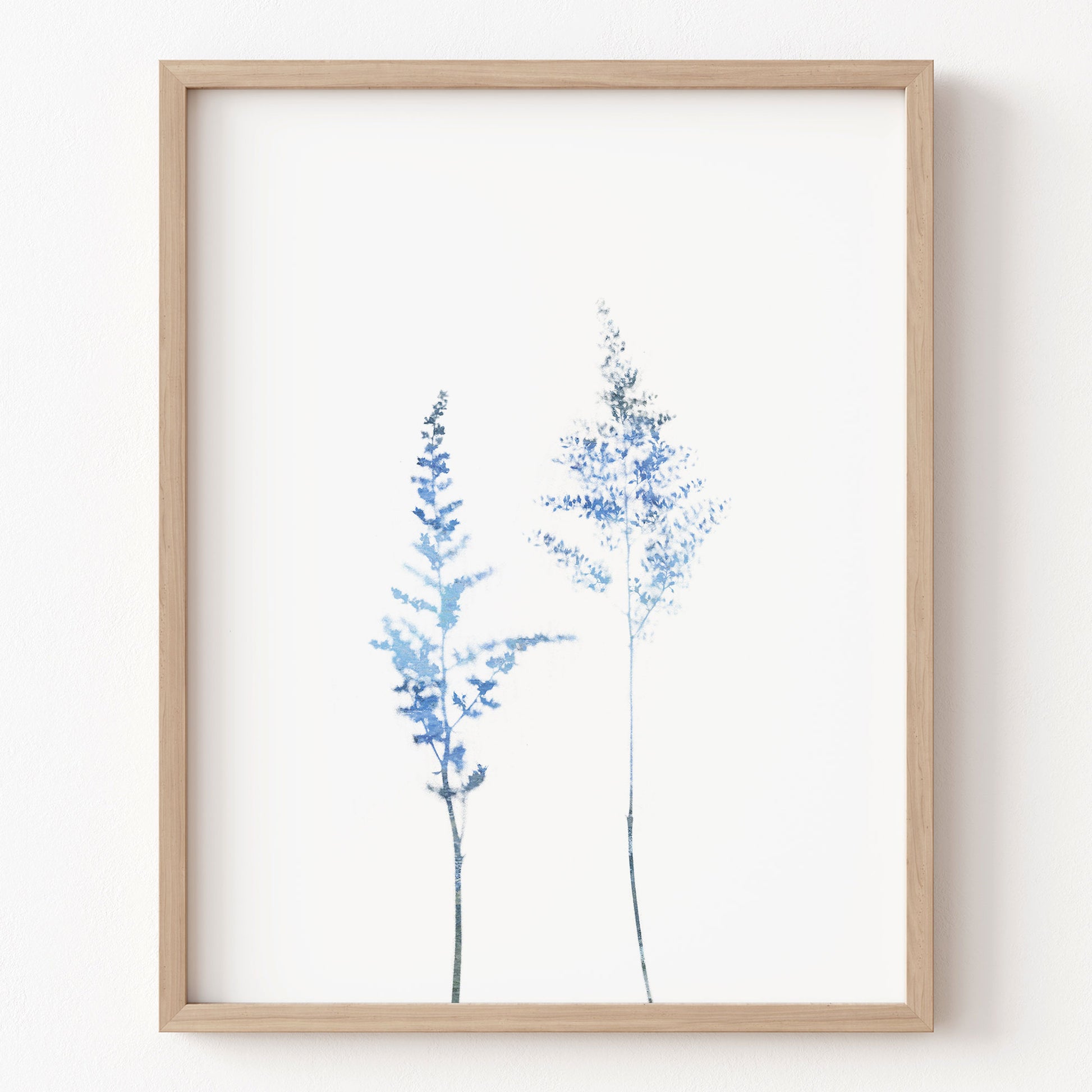 Framed artwork of blue floral branches on a white background