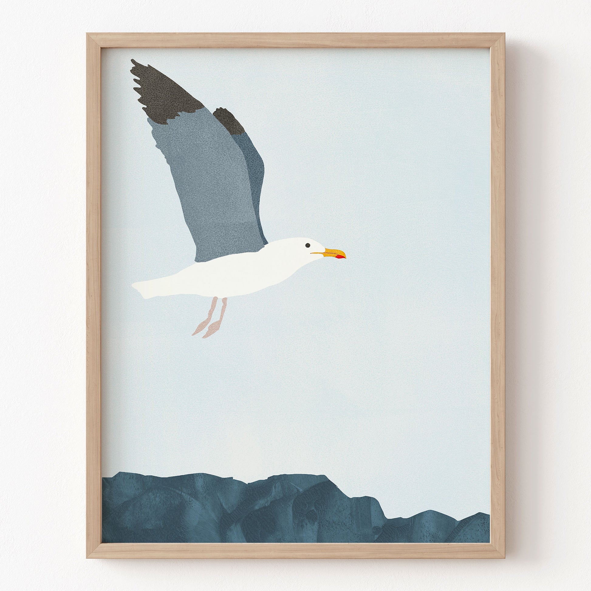 Framed artwork of a seagull flying over water on a light blue background