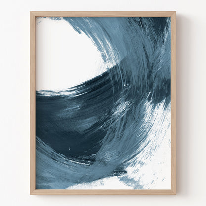 Framed abstract art print with blue and white brush strokes on a white wall.