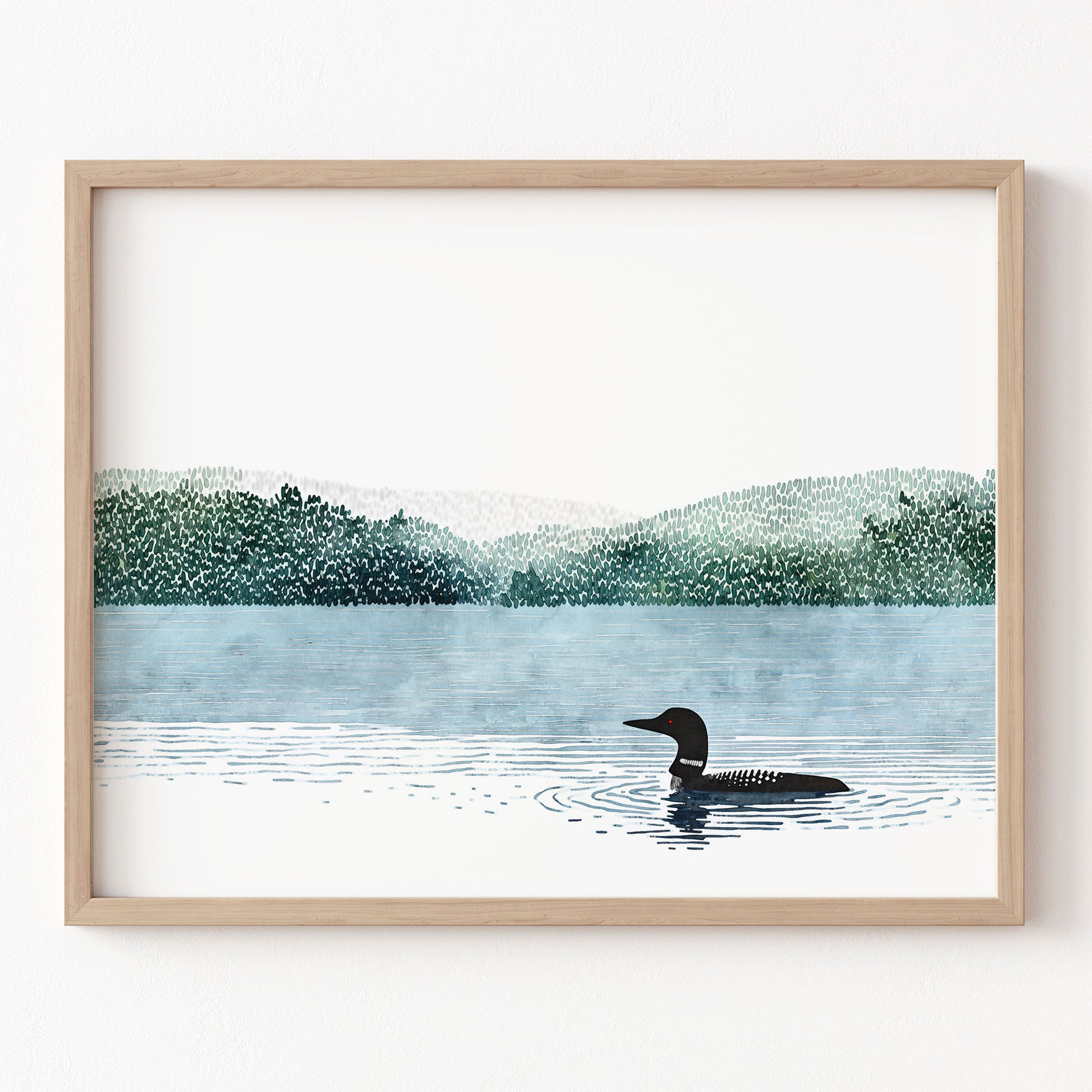 Framed artwork of a loon on a lake with trees in the background
