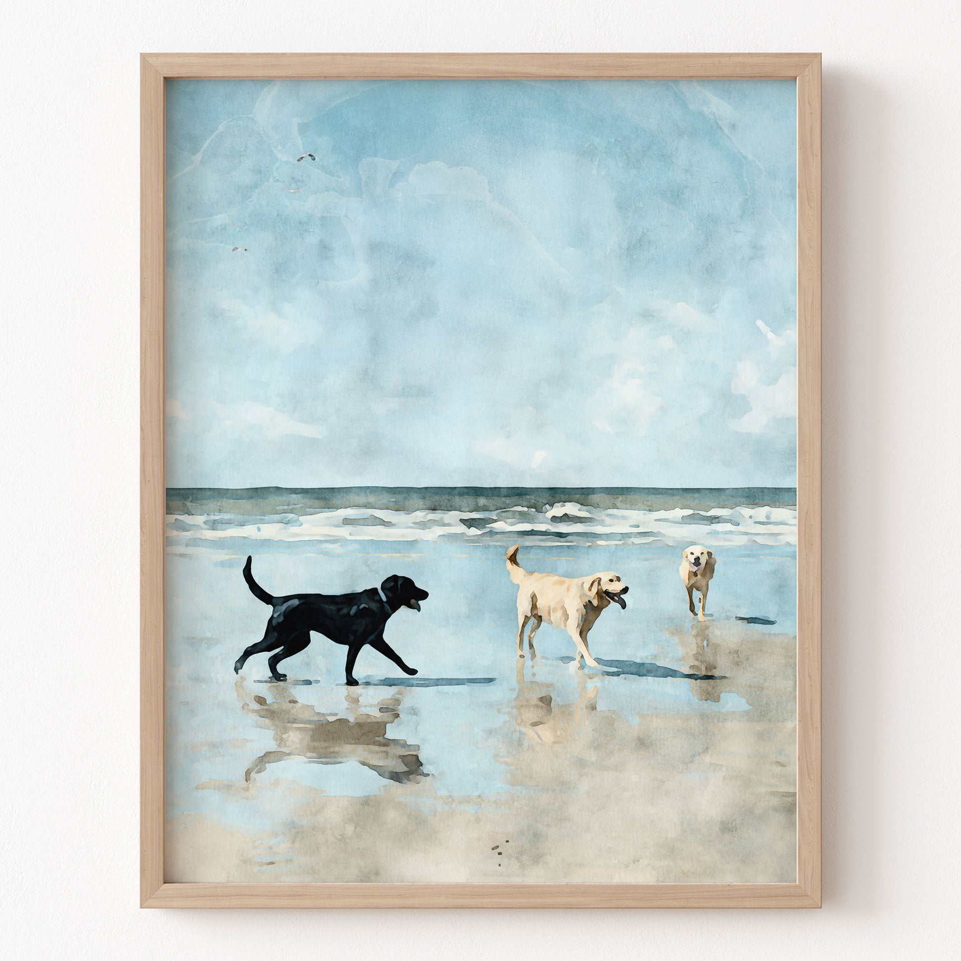 Framed artwork of three dogs on a beach with a blue sky.